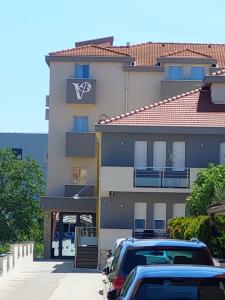 默主歌耶Hotel Vesna的前面有汽车停放的建筑