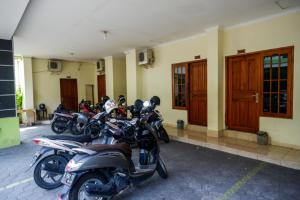 日惹RedDoorz At Hotel Sartika Yogyakarta的停在大楼前的一排摩托车
