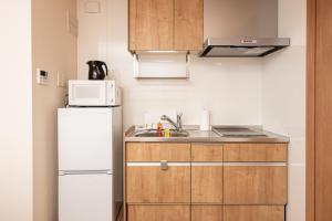 鹿儿岛T・Kスクエア鹿児島中央的小厨房配有冰箱和微波炉。