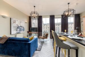爱丁堡ALTIDO Luxury flats in Old Town, right on Royal Mile的客厅配有蓝色的沙发和桌子