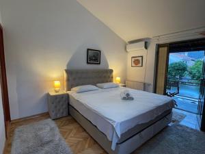 布德瓦Apartment Ruzica的一间卧室配有一张带两盏灯的床和一个阳台