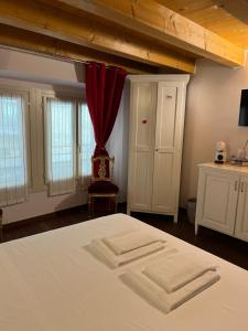 维罗纳斯帕德4号旅馆的一间卧室配有床和红色窗帘