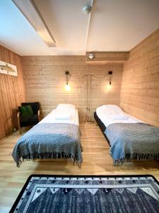 阿尔维斯尧尔Lumi Guest House的木墙客房的两张床