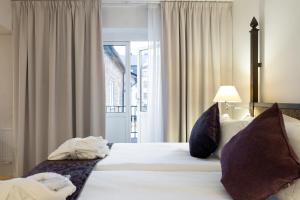 斯德哥尔摩瑞典精英酒店的卧室配有一张大白色床和窗户
