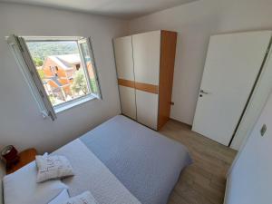 斯拉诺Apartments Šišević - Comfort Apartments with Balconies and Sea View的一间小卧室,配有床和窗户