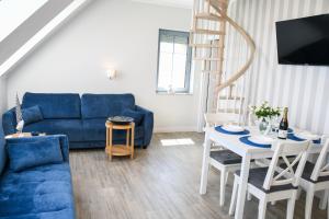 德布吉Apartamenty Wrzosowa的客厅配有蓝色的沙发和桌子