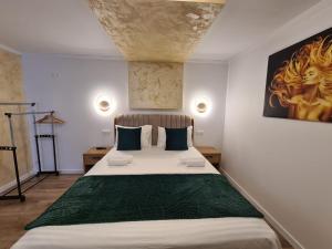 图尔达Bella Vista Bungalow的卧室配有一张大床,墙上挂有绘画作品