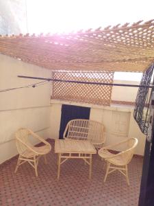 拉巴特Maison vintage Rabat Agdal的庭院配有两把椅子、一张桌子和一张桌子以及椅子。
