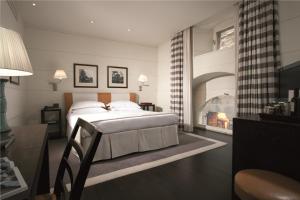 佛罗伦萨艺术画廊酒店 - 朗伽诺酒店集团的一间卧室设有一张大床和一个壁炉
