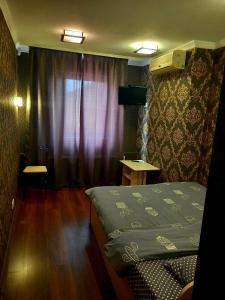 敖德萨洛丁娜酒店的小房间设有床和窗户
