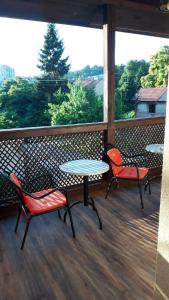 图兹拉Apartment and rooms"Tabašnice"Tuzla centar的阳台上配有2张桌子和椅子,享有树林美景