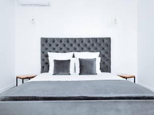 切尔诺莫斯克Klaster SeaView Hotel的一间卧室配有一张大床和灰色床头板
