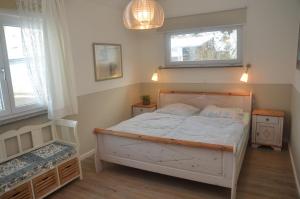 厄赫宁根Hoeri Ferienhaus -Lake Constance的卧室配有白色床和2扇窗户