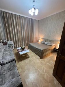 第比利斯格鲁吉亚酒店的一间卧室配有一张床、一张桌子和一张沙发