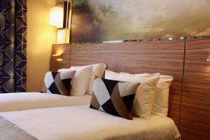 巴黎Hotel Le Rocroy的酒店客房带两张床和一个大床头板