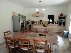 BanatA LA JOIE DE VIVRE Chez l'habitant的厨房配有大型木桌和椅子