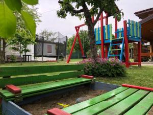 KonskaVilla Jerman的公园里的绿色长凳,带游乐场