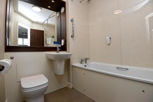 邓巴Pine Marten, Dunbar by Marston's Inns的浴室配有卫生间、盥洗盆和浴缸。