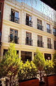 伊斯坦布尔BALPETEK HOTEL的一座带阳台的建筑,前面有树木