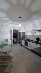 泰尔莫利Maison D’aMi’的厨房配有桌子和墙上的时钟