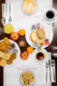 沃洛斯飞利浦酒店的一张桌子,上面有两盘早餐食品