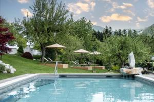 瑟尔阿鹏斯勒索酒店的一座大游泳池,位于一个树木繁茂的庭院内