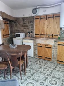 托里迪蒙科尔武Vita Portucale ! Countryside Cottage Gem Moncorvo的厨房配有木制橱柜和木桌。