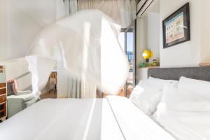 塞萨洛尼基卡拉万住宿加早餐旅馆的卧室配有白色床单和白色床。