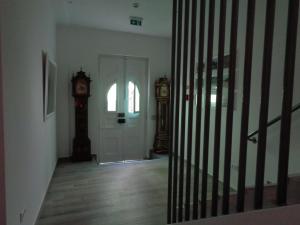 奥德赛克斯AL-Odeceixe Verde的走廊上设有门和祖父钟