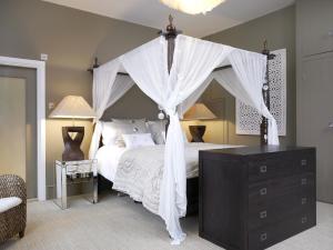 克劳利温德伏尔精品酒店的卧室配有带白色窗帘的天蓬床