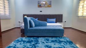 努瓦克肖特Hotel Suites TALHAYA, NOUAKCHOTT的客厅配有蓝色椅子和一张床