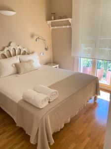 巴塞罗那佩蒂特罗瑟洛公寓的一间卧室配有一张大床和毛巾