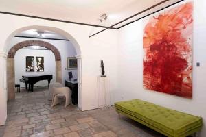特拉帕尼B&B Cantiere dell'anima - Rooms of art的客厅配有绿色长凳和钢琴