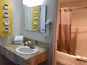 米苏拉Travelodge Inn & Suites by Wyndham Missoula University Park的一间带水槽和淋浴的浴室