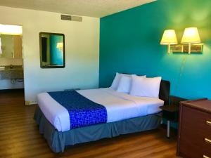 米苏拉Travelodge Inn & Suites by Wyndham Missoula University Park的一间位于酒店客房内的带大床的卧室