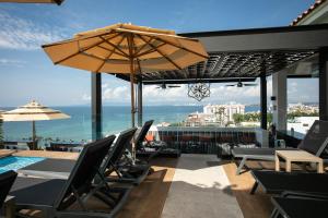 巴亚尔塔港Pinnacle Resorts 179 - Adults Only的一个带椅子和遮阳伞的庭院和一个游泳池