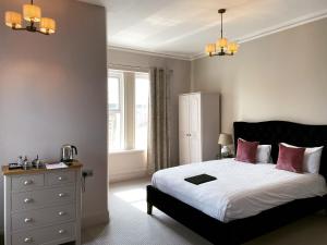 托基The Rosewood Torquay的一间卧室配有带白色床单和粉红色枕头的床。