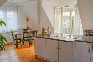 施派尔Traumhaft wohnen in Jugendstilvilla的厨房配有白色橱柜、桌子和窗户。