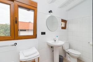 苏安塞斯BENEDICTA FAMILY ROOMS的一间带水槽和卫生间的浴室以及窗户。