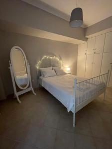 雅典Demi’s garden near the metro of Athens的卧室配有白色的床和镜子