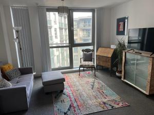 伯明翰Lovely City centre 1 bed apartment with free on site parking by Lets Relocations的客厅配有沙发和椅子