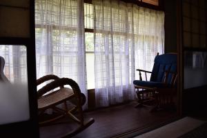 长滨市Guest House Miei - Vacation STAY 87536v的一间设有两把椅子和窗帘的窗户的房间