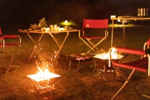 佐渡市guesthouse UZU Sado - Vacation STAY 90684v的夜间 ⁇ 火周围的桌椅