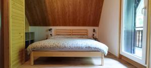 伊利尔斯卡比斯特里察Koča Kresnica的一间卧室配有一张带木制床头板的床