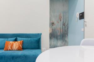 Le MarmoreAria Marmore的客房内的蓝色沙发,配有橙色枕头