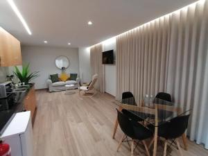 丰沙尔Apartments Madeira Funchal City的客厅配有玻璃桌和椅子