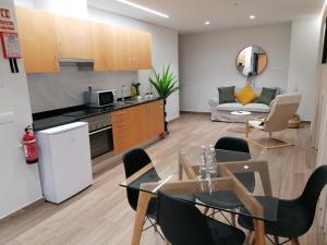 丰沙尔Apartments Madeira Funchal City的厨房以及带桌椅的起居室。