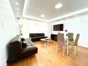 基多ItsaHome Apartments - Torre Seis的客厅配有黑色沙发和桌子