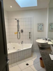 新普利茅斯尼斯酒店的带浴缸和盥洗盆的浴室