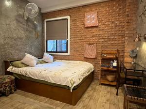 清道清佬阿时旅馆的一间卧室设有一张床和砖墙